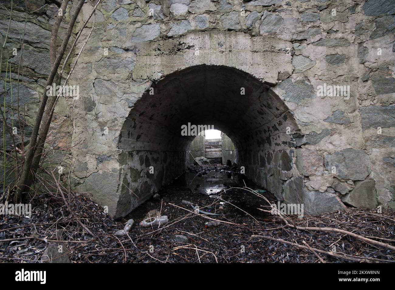 Cullvert, scolo sotto la strada per piccolo fiume. Cemento sotterraneo è una struttura che permette che acqua fluisca sotto una strada da un lato all'altro. Foto Stock