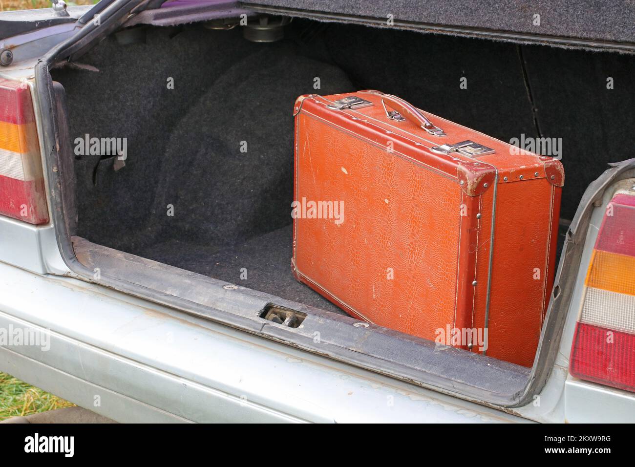 Una vecchia valigia nel bagagliaio di una vecchia macchina. Concetto di viaggio. Foto Stock
