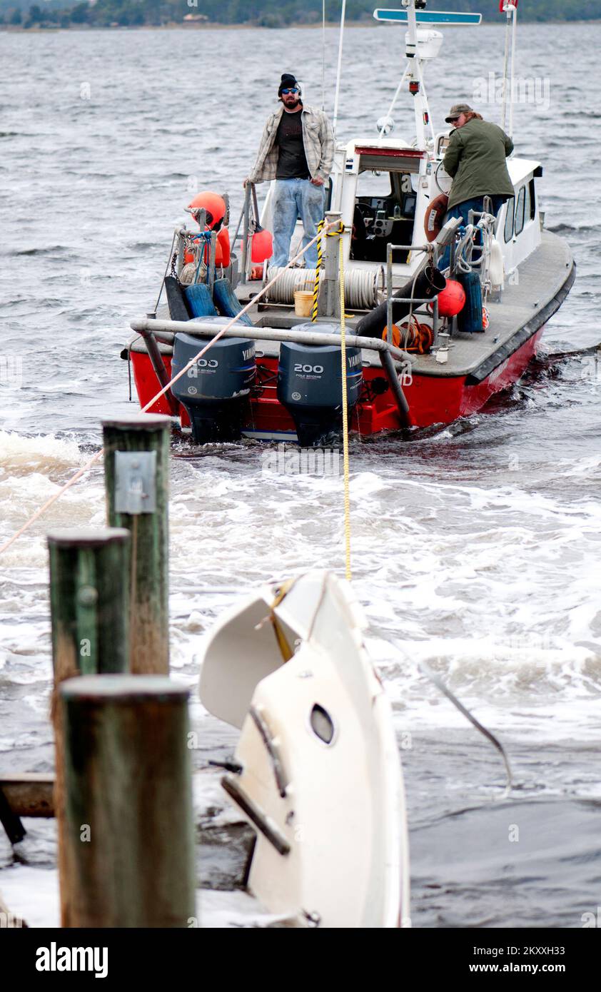 Ocean City, Md., 5 novembre 2012 due uomini cercano di liberare e impigliare la barca da un molo danneggiato nella baia di Assawoman nella città di Ocean City, MD. FEMA ha fatto un giro in città per cercare danni causati dall'uragano Sandy. Maryland uragano Sandy. Fotografie relative a disastri e programmi, attività e funzionari di gestione delle emergenze Foto Stock