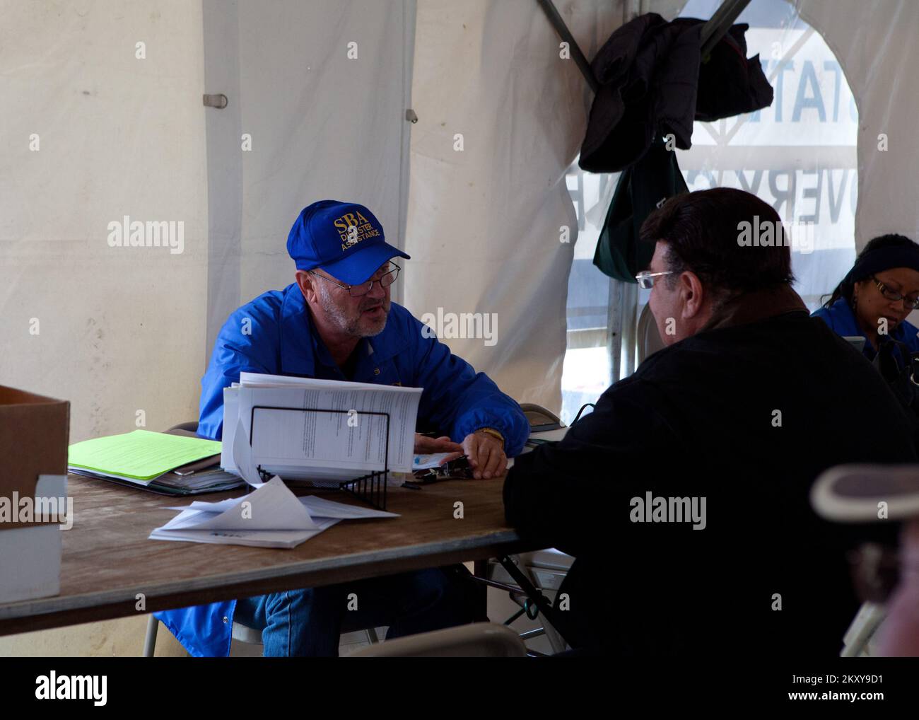 Staten Island, N.Y., 10 novembre 2012 Uno specialista di Small Business Administration (SBA) aiuta un superstite nel processo di applicazione presso un Centro di recupero di emergenza (DRC) a Staten Island. L'ASB aiuta con i prestiti di disastro di interesse bassi per i commerci e gli individui. . L'uragano Sandy di New York. Fotografie relative a disastri e programmi, attività e funzionari di gestione delle emergenze Foto Stock