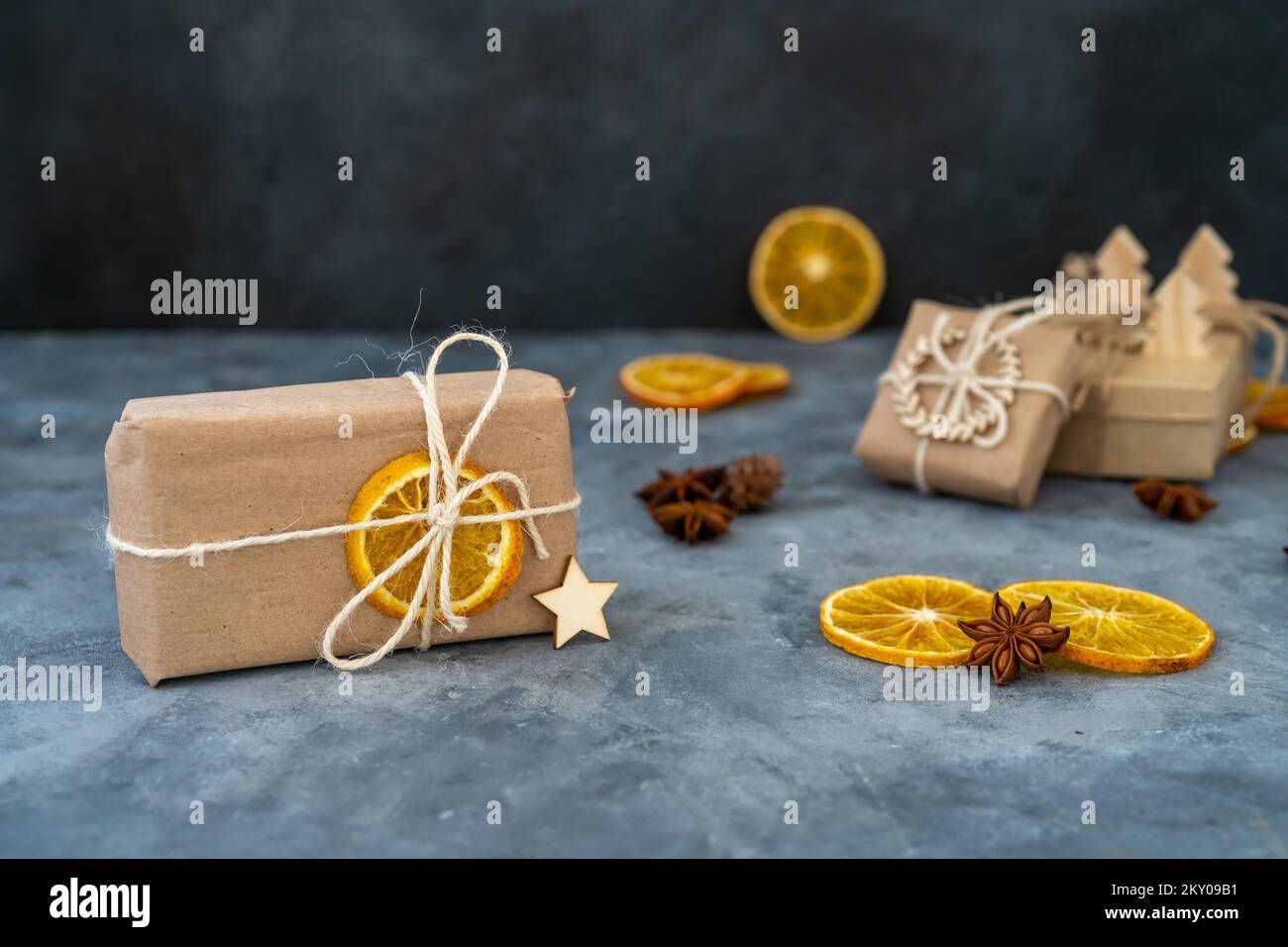 Zero spreco Natale concetto. Carta kraft ecologica che avvolge i regali su un tavolo in ardesia. Articoli da regalo fai da te, arredamento eco-compatibile. Spazio di copia, banner. Foto Stock