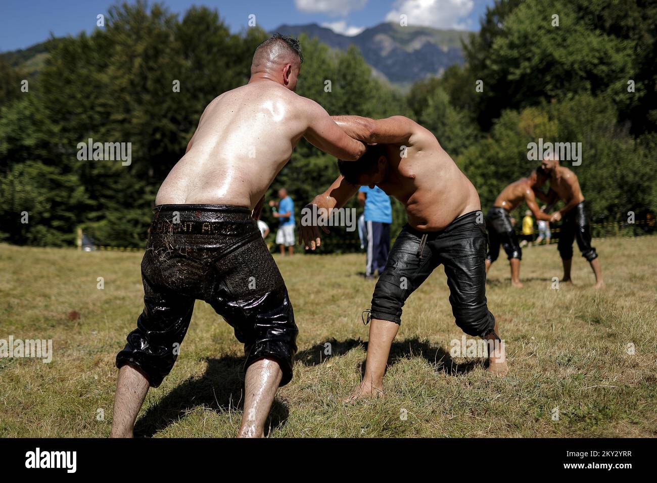 Gli acrobati si aggrappano in una tradizionale partita di lotta contro il petrolio chiamata 'Pelivani' durante la festa della circoncisione nel villaggio di Donje Ljubinje, Kosovo, 03 agosto 2022. Ogni cinque anni la gente del villaggio organizza un festival Ã”SunetÅ (circoncisione). più di 70 bambini del villaggio sono stati circoncisi quest'anno. Tutti i membri del villaggio si riuniscono, tra cui molti che vivono all'estero da Svizzera, Stati Uniti, Svezia e Germania, per il festival di tre giorni. Torbes Bosniaks sono abitanti che popolano il villaggio di Donje Ljubinje che si trova nelle montagne Shar che formano il boro Foto Stock