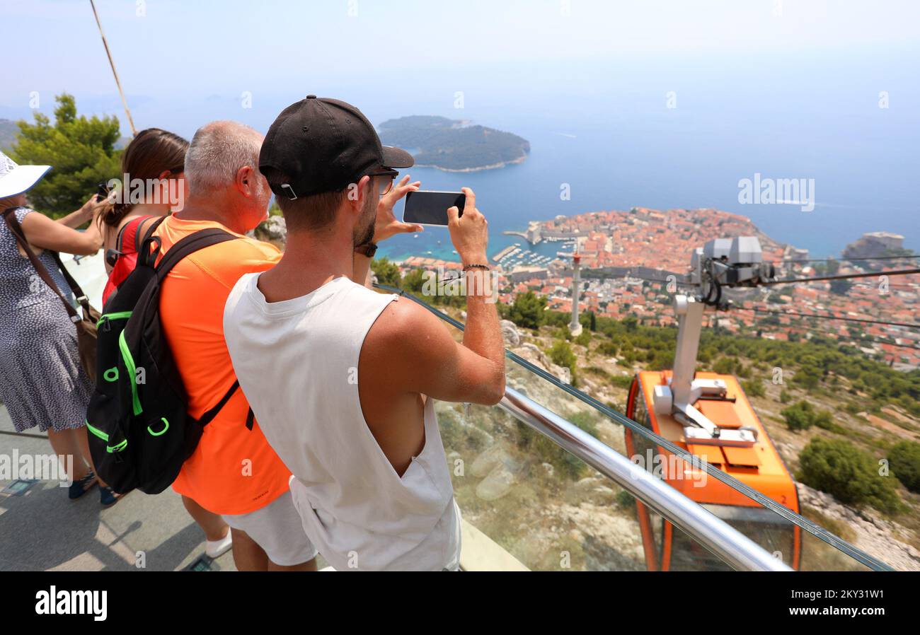 Numerosi turisti vengono in funivia alla collina di Srdj, dove godono di una bella vista di Dubrovnik, Croazia il 11 agosto 2022. Foto Stock