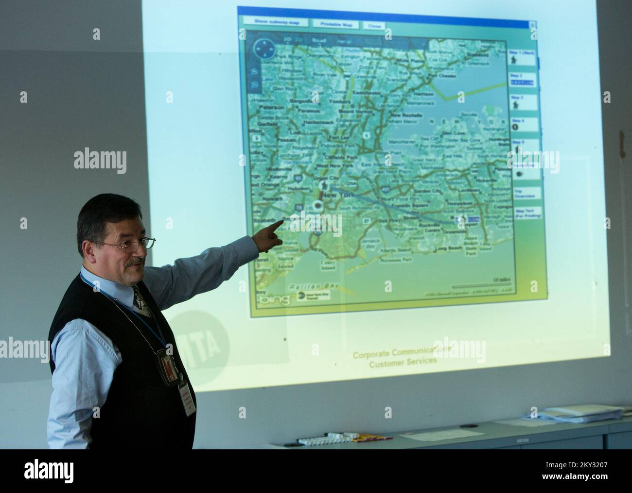 Forest Hills, N.Y., 5 dicembre 2012 Ozzie Cruz, New York MTA Customer Service Trainer, conduce un seminario di formazione sulla guida del sistema di transito di New York City presso il FEMA Joint Field Office di Forest Hills, N.Y. La FEMA collabora con vari partner, tra cui governi federali, statali e locali e tribali, organizzazioni volontarie basate sulla fede e sulla comunità, insieme al settore privato, per assistere i residenti colpiti dall'uragano Sandy. Chris Kleponis/FEMA. L'uragano Sandy di New York. Fotografie relative a disastri e programmi, attività e funzionari di gestione delle emergenze Foto Stock