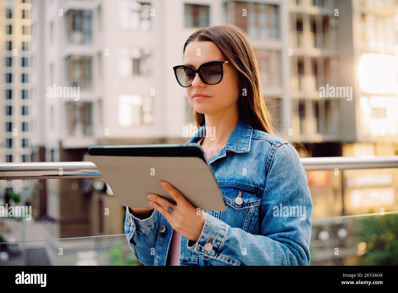 Giovani donne d'affari millennial in occhiali che camminano nel quartiere finanziario della città utilizza tablet digitali nei social network, connessione, dati, display digitale Foto Stock