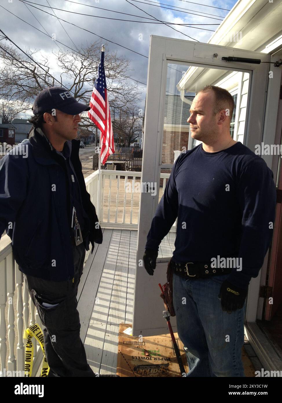 Seaside Heights, N.J., 11 dicembre 2012 lo specialista delle relazioni con la comunità Robert Stewart parla con SSG Jimmy Urcinoli, che sta aiutando a ripristinare la casa del padre dopo i danni causati dall'uragano Sandy. I team di Relazioni con la comunità FEMA sono ancora sul campo, inseguendo i rapporti nei quartieri per fornire informazioni sull'assistenza in caso di catastrofi. New Jersey Hurricane Sandy. Fotografie relative a disastri e programmi, attività e funzionari di gestione delle emergenze Foto Stock