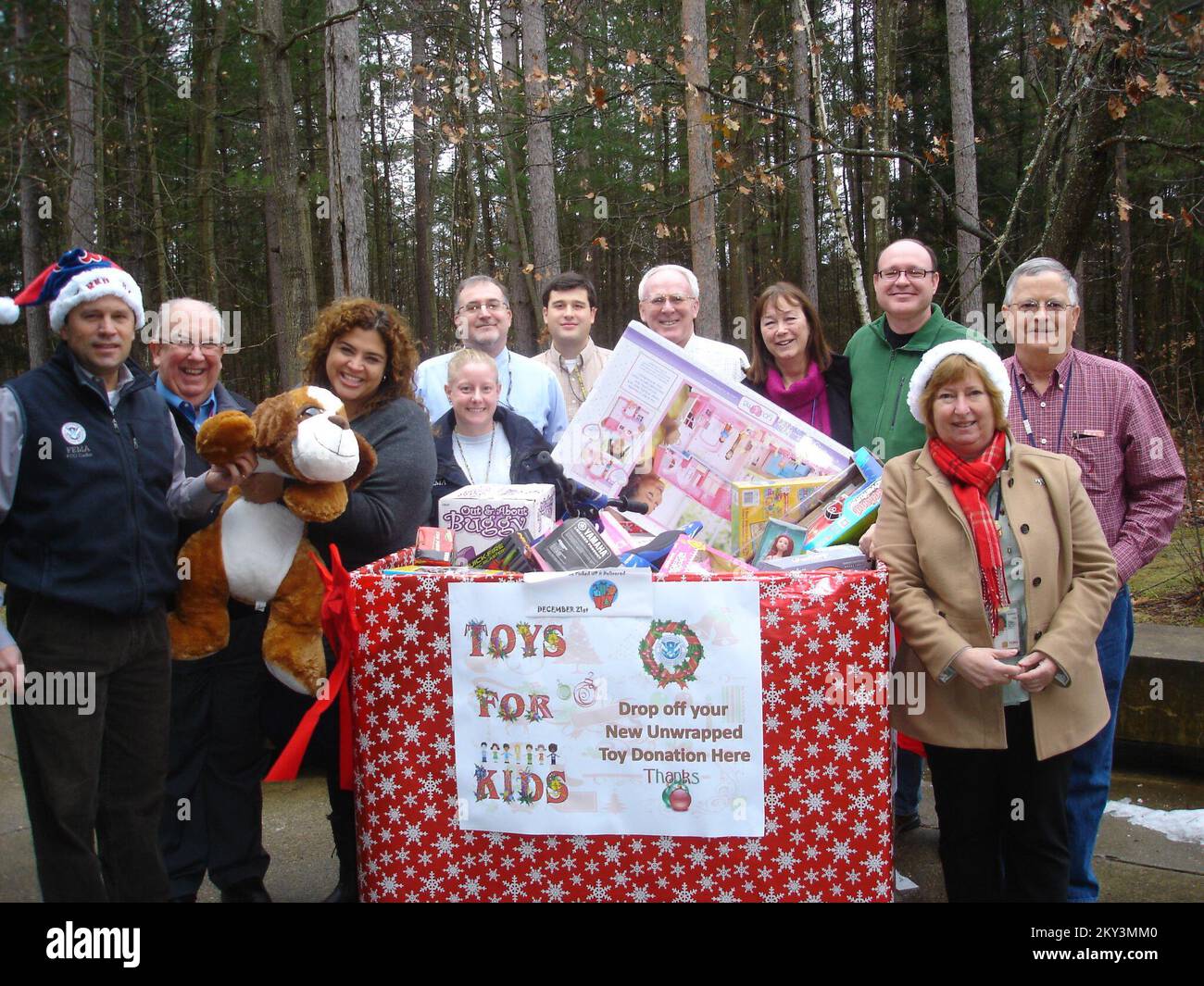 Essex Junction, Vt., 21 dicembre 2012, il coordinatore federale Mark Landry, che indossa un cappello, e il personale DR-4022-VT hanno partecipato a un viaggio volontario 'Giocattoli per bambini' per i bambini della zona. Il personale della FEMA tratta i propri partner federali, statali, tribali, locali e del settore privato con la dignità che ogni partner merita. Vermont Tropical Storm Irene. Fotografie relative a disastri e programmi, attività e funzionari di gestione delle emergenze Foto Stock