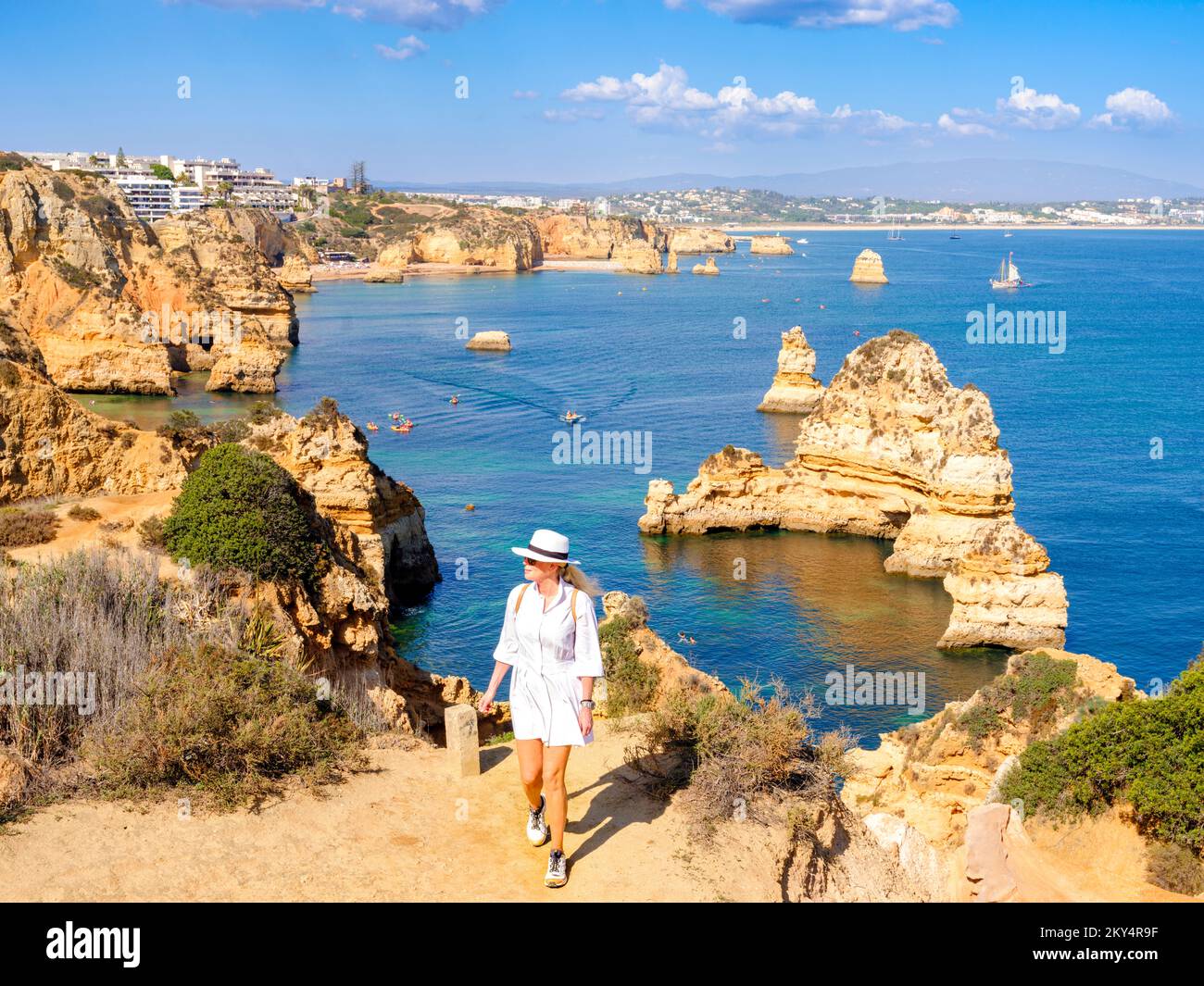 Donna in viaggio da solo, Donna godendo la vista Camilo Beach Camilo Beach, Praia do Camilo, formazione di scogliere naturali e Beach Cove Lagos, Algarve, Portugal Foto Stock