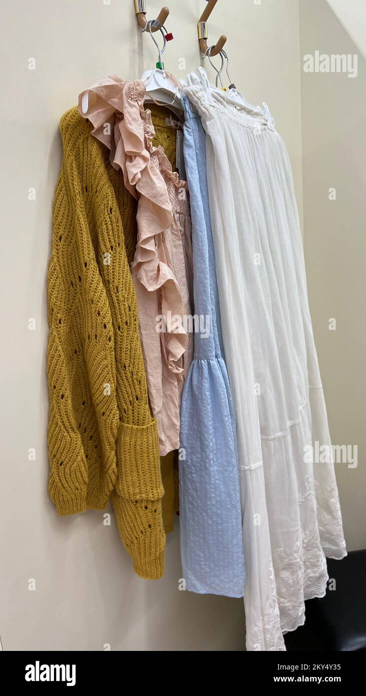 Primo piano di vestiti di colore blu, ocra, rosa e bianco appesi su un  gancio Foto stock - Alamy