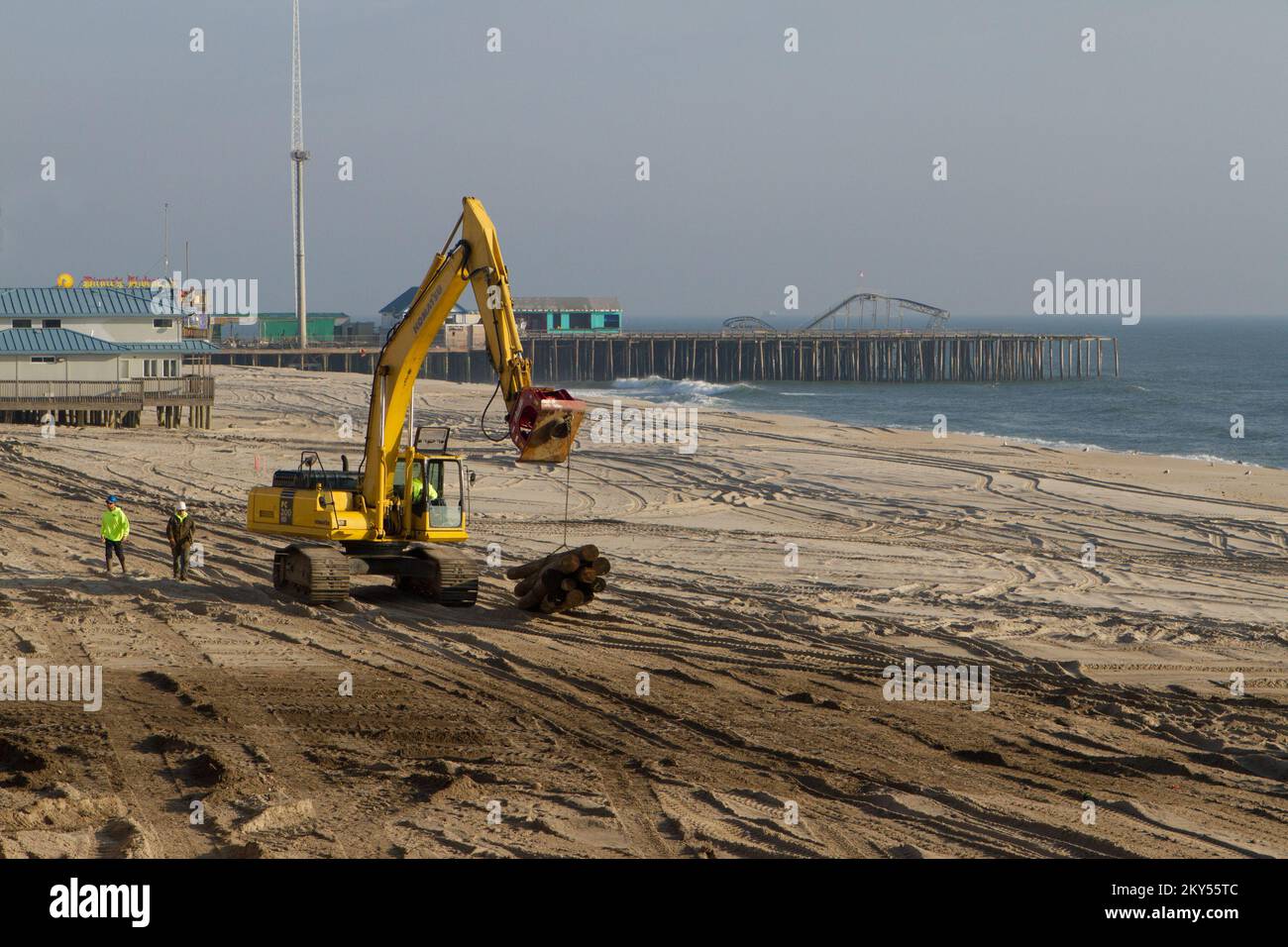 Seaside Heights, N.J., 15 febbraio 2013 escavatore e lavoratori trasportano pali in cantiere per il restauro del lungomare di Seaside Heights danneggiato dall'uragano Sandy. L'obiettivo della città è di guidare 65 pali al giorno, sostituire le tavole e avere il lungomare pronto per il Memorial Day. New Jersey Hurricane Sandy. Fotografie relative a disastri e programmi, attività e funzionari di gestione delle emergenze Foto Stock