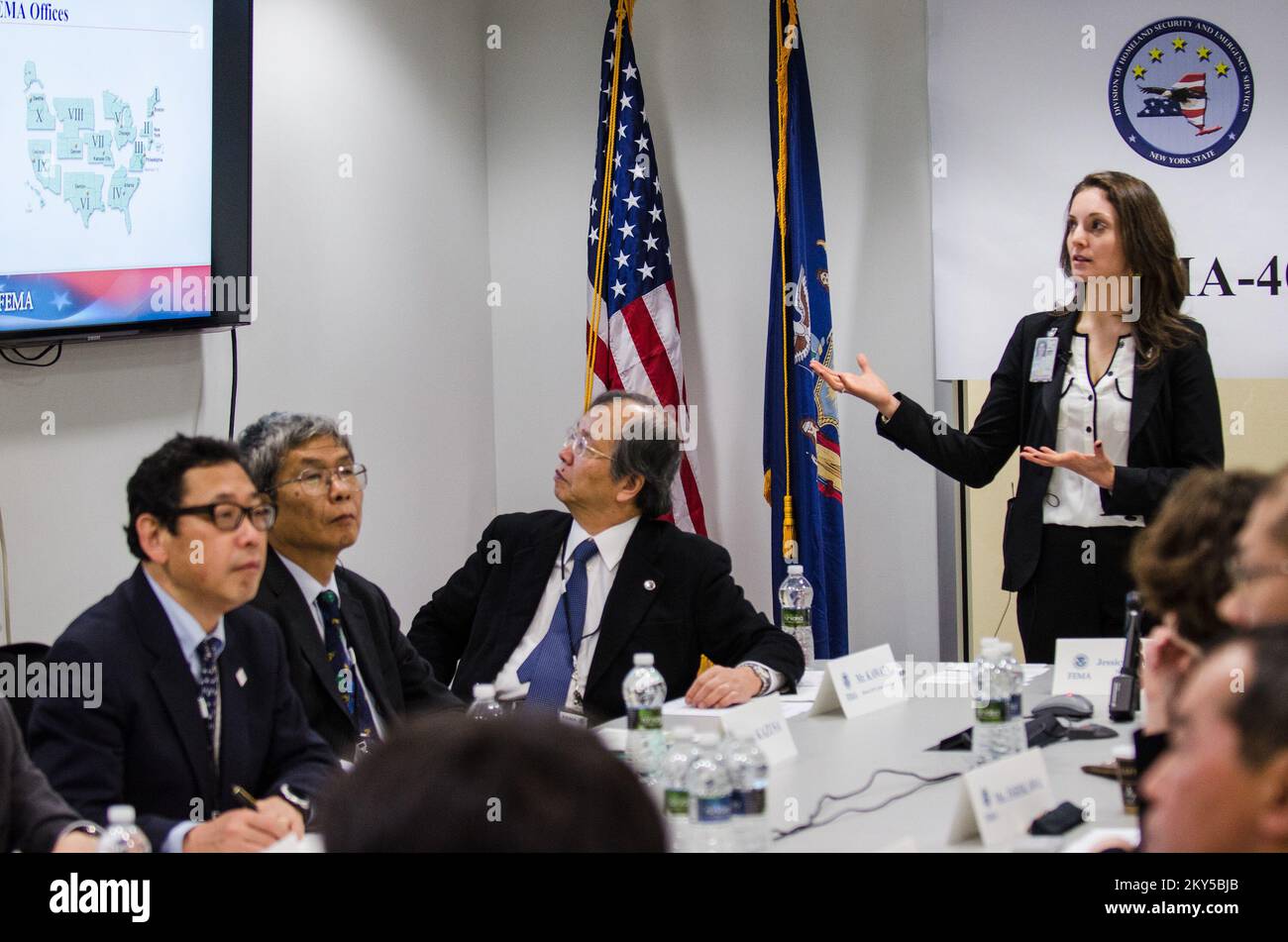 Queens, N.Y., 28 febbraio 2013 la FEMA ha ospitato un team di gestione delle emergenze giapponese presso il JFO (Joint Field Office) di NY per informarli sulle operazioni di ripristino di emergenza per l'uragano Sandy. Jessica Steinbeck, International Visitor Coordinator, presenta una panoramica della FEMA. K.C.WILSEY/FEMA. L'uragano Sandy di New York. Fotografie relative a disastri e programmi, attività e funzionari di gestione delle emergenze Foto Stock