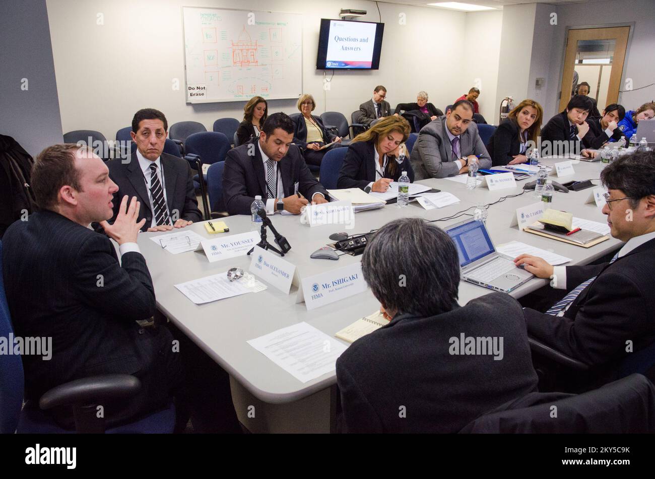 Queens, N.Y., 28 febbraio 2013 la FEMA ha ospitato squadre di gestione delle emergenze provenienti dal Giappone e dalla Lega araba, presso il JFO (New York Joint Field Office) per informarli sulle operazioni di ripristino di emergenza per l'uragano Sandy. DaN Alexander (a sinistra), Vice funzionario federale di coordinamento per la ripresa, discute la strategia di sostegno alla ripresa della FEMA che sta avendo luogo per ricostruire e ripristinare le comunità danneggiate dall'uragano Sandy. K.C.WILSEY/FEMA.. Fotografie relative a disastri e programmi, attività e funzionari di gestione delle emergenze Foto Stock