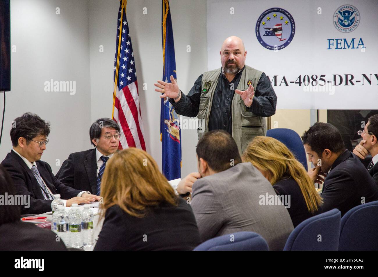 Queens, N.Y., 28 febbraio 2013 la FEMA ha ospitato squadre di gestione delle emergenze provenienti dal Giappone e dalla Lega araba, presso il JFO (New York Joint Field Office) per informarli sulle operazioni di ripristino di emergenza per l'uragano Sandy. Michael Smith, Vice Direttore operativo della filiale, discute la logistica di prepararsi a un disastro. K.C.WILSEY/FEMA. L'uragano Sandy di New York. Fotografie relative a disastri e programmi, attività e funzionari di gestione delle emergenze Foto Stock