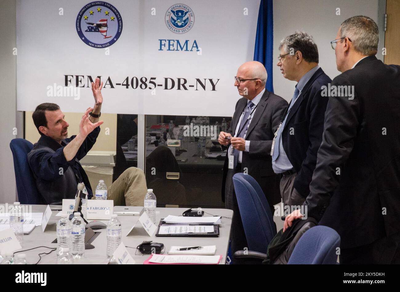 Queens, N.Y., 5 marzo 2013 la FEMA ha ospitato un team di gestione delle emergenze francese presso il JFO (Joint Field Office) di NY per informarli sulle operazioni di ripristino di emergenza per l'uragano Sandy. Tom Fargione, responsabile della sezione operazioni, discute la logistica della risposta ai disastri. K.C.WILSEY/FEMA. L'uragano Sandy di New York. Fotografie relative a disastri e programmi, attività e funzionari di gestione delle emergenze Foto Stock