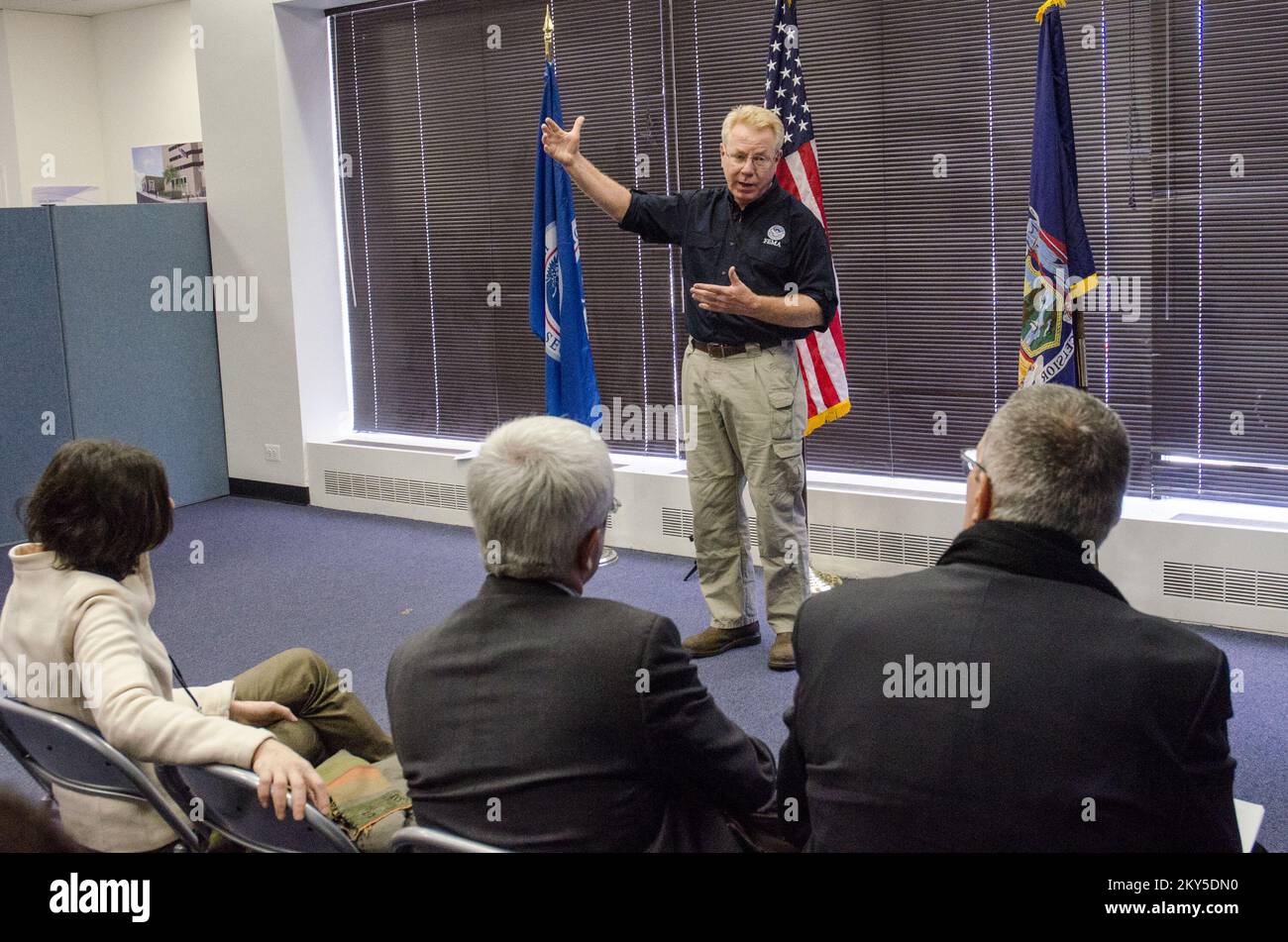 Queens, N.Y., 5 marzo 2013 la FEMA ha ospitato un team di gestione delle emergenze francese presso il JFO (Joint Field Office) di NY. Michael Byrne, funzionario federale di coordinamento, fornisce informazioni ai visitatori sulle operazioni di risposta e recupero della FEMA all'uragano Sandy. K.C.WILSEY/FEMA. L'uragano Sandy di New York. Fotografie relative a disastri e programmi, attività e funzionari di gestione delle emergenze Foto Stock