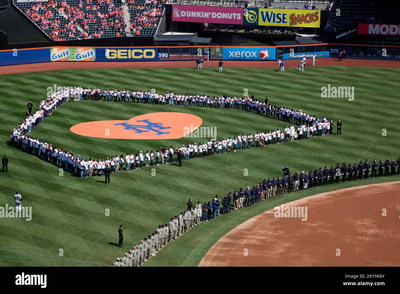 Flushing, N.Y., 1 aprile 2013 i soccorritori e i volontari dell'uragano Sandy sono stati onorati al Citi Field durante la cerimonia pre-partita per il giorno di apertura del Mets. Più di 500 soccorritori dell'uragano Sandy si sono schierati sul campo per l'inno nazionale, inclusi rappresentanti della FEMA, polizia, vigili del fuoco, personale militare e volontari Habitat for Humanity. Ashley Andujar/FEMA. L'uragano Sandy di New York. Fotografie relative a disastri e programmi, attività e funzionari di gestione delle emergenze Foto Stock