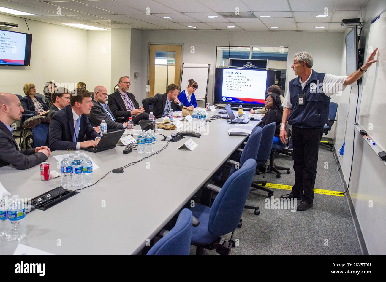 Queens, N.Y., 25 aprile 2013 la FEMA ha ospitato funzionari municipali e di gestione delle emergenze di Stoccolma, Svezia presso il JFO (New York Joint Field Office) per informarli sulle operazioni di ripristino di emergenza per l'uragano Sandy. Park Owens, responsabile della sezione operazioni FEMA, discute i diversi aspetti della risposta. K.C.WILSEY/FEMA. L'uragano Sandy di New York. Fotografie relative a disastri e programmi, attività e funzionari di gestione delle emergenze Foto Stock