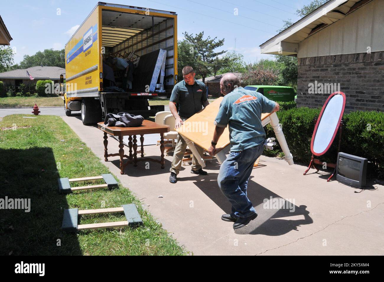 Ovest, Texas, 8 maggio 2013 lavoratori della società di restauro caricare una tavola recuperata da una casa danneggiata dall'esplosione di impianto di fertilizzante di aprile 17. La FEMA sta aiutando i residenti a riprendersi dal disastro. Norman Lenburg/FEMA. Norman Lenburg/FEMA. Fotografie relative a disastri e programmi, attività e funzionari di gestione delle emergenze Foto Stock