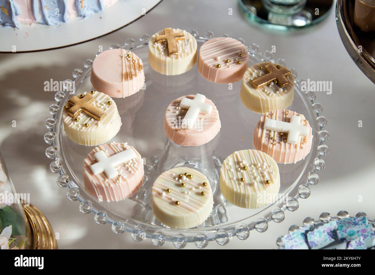 Piccoli dolci di prima comunione sul tavolo da dessert per una festa Foto Stock
