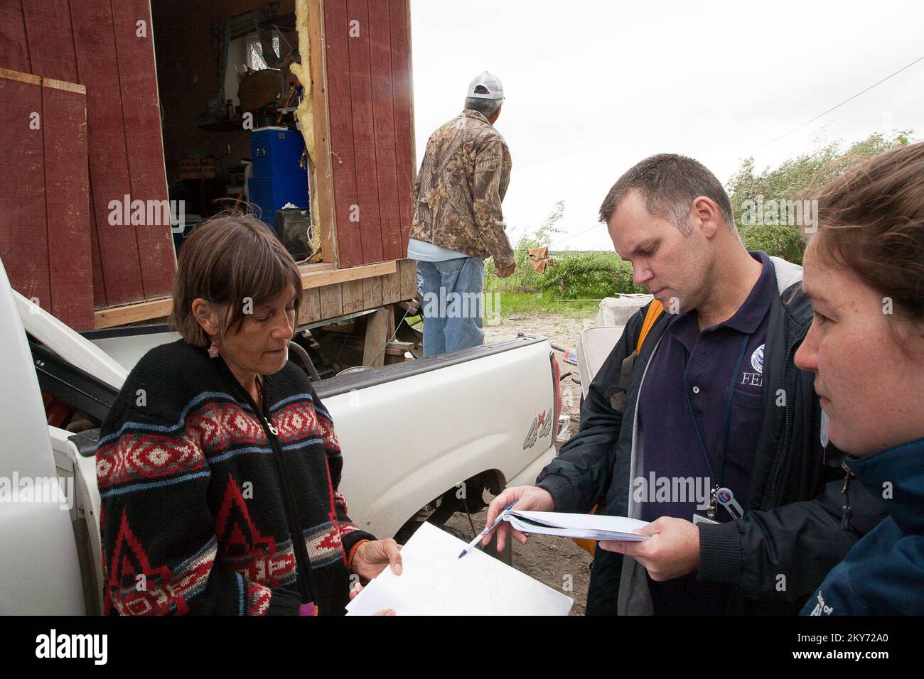Galena, Alaska, 1 luglio 2013 Alyson Esmailka è assistita da Ron Wilson della FEMA e Mariel Fonteyn dello Stato con procedure utili per ottenere aiuti per i suoi danni. La FEMA e gli specialisti statali sono a disposizione per assistere i cittadini che hanno subito danni a causa di catastrofi. Fotografie relative a disastri e programmi, attività e funzionari di gestione delle emergenze Foto Stock