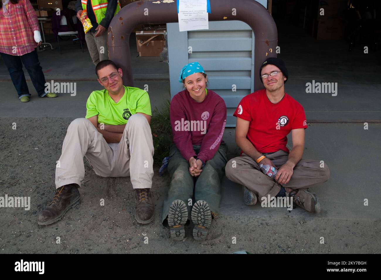 Galena, Alaska, 23 luglio 2013 Ryan Elliott, Erica Redzinak e Henry Moss si rilassano prima di ricevere gli ordini di marcia della loro giornata. I team AmeriCorps possono avere un grande impatto sulle riprese in caso di disastri con il loro contributo di manodopera qualificata. Fotografie relative a disastri e programmi, attività e funzionari di gestione delle emergenze Foto Stock