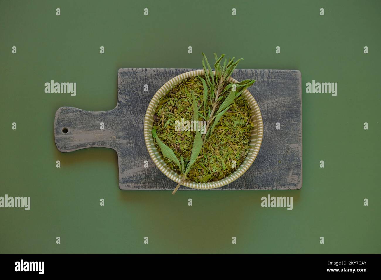 Stevia essiccata e ramoscello verde in una tazza rotonda su un legno board.Sugar sostituto. Dolcificante dietetico naturale. Foto Stock