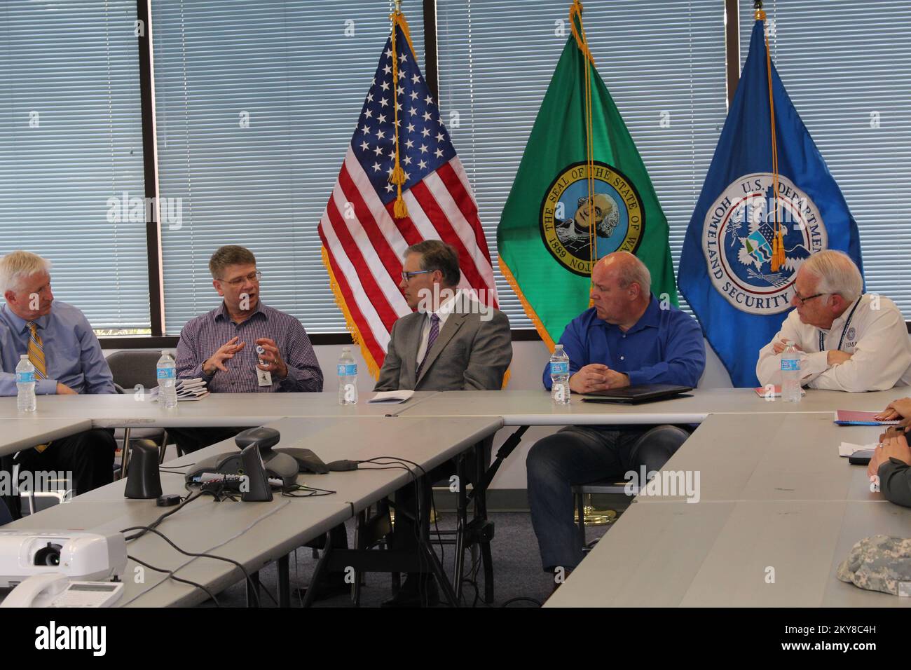 Everett, Washington, 15 aprile 2014 Direttore di Stato della Divisione di Gestione delle emergenze del Dipartimento militare di Washington, Robert Ezelle, ufficiale di coordinamento di Stato, Kurt Hardin, Governatore di Stato di Washington, Jay Inslee e l'amministratore regionale Ken Murphy discutono delle operazioni di ripristino presso la diapositiva SR530 del sito di emergenza, nonché degli sforzi di coordinamento tra i governi statali, locali e federali. Inondazioni e frane di Washington. Fotografie relative a disastri e programmi, attività e funzionari di gestione delle emergenze Foto Stock