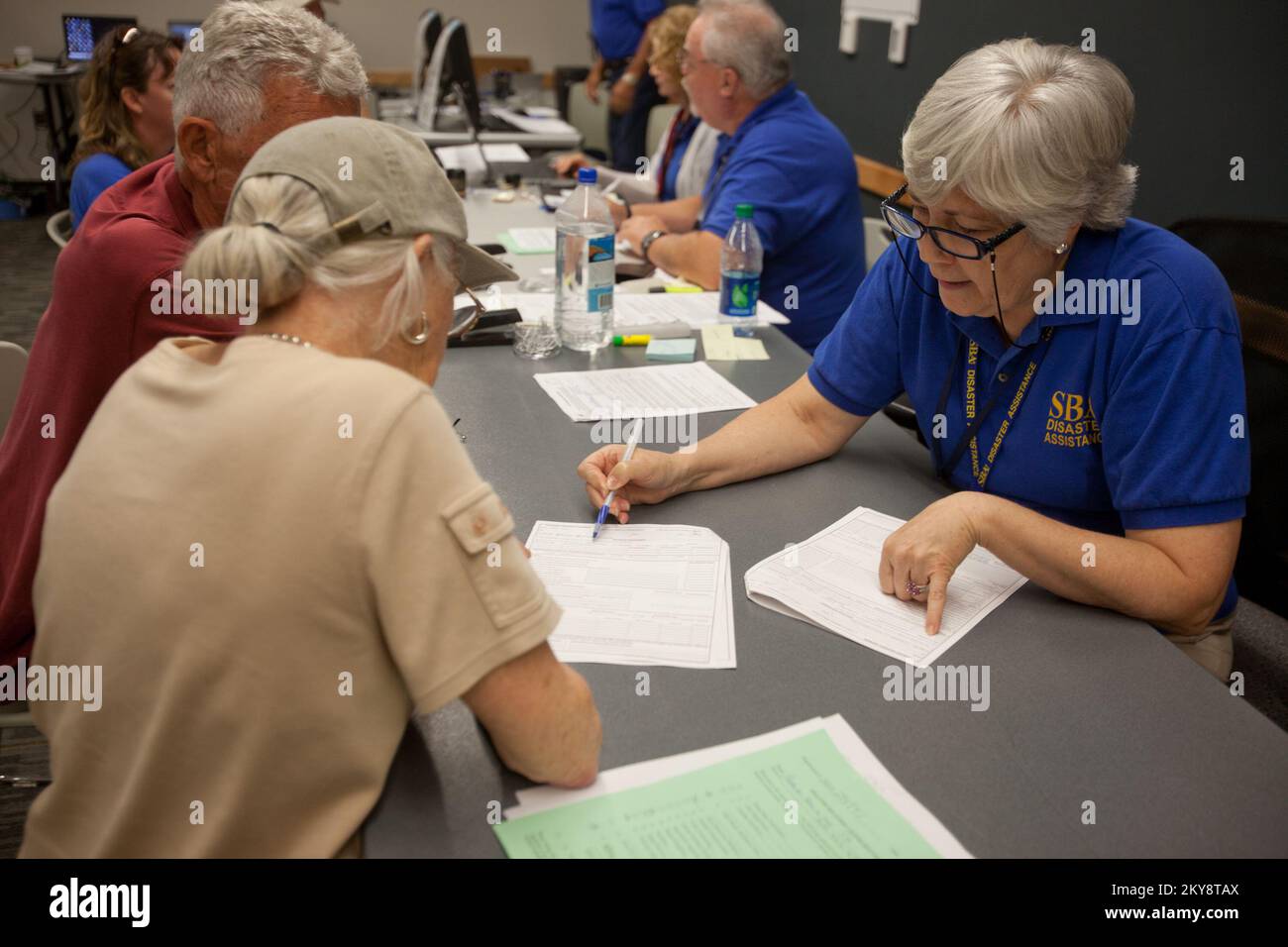 Pensacola, Flah., 10 maggio 2014 rappresentante della Small Business Administration (SBA), Lynne Manthei assiste i richiedenti di un prestito per catastrofi naturali presso un Centro di recupero di emergenza (DRC) a Gulf Breeze, Florida. A seguito di un'alluvione lampo lungo alcune parti del Florida Panhandle, la DRC è stata fondata nelle comunità per assistere i sopravvissuti alle catastrofi con l'assistenza delle agenzie locali, statali e federali. Andrea Booher/FEMA. Florida forti tempeste, tornado, venti in linea retta e alluvioni. Fotografie relative a disastri e programmi, attività e funzionari di gestione delle emergenze Foto Stock
