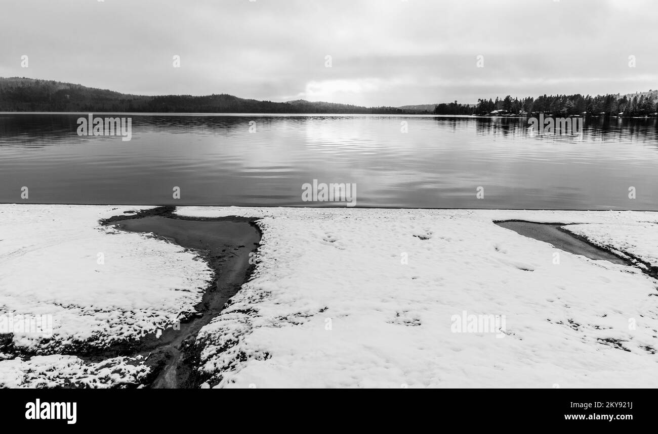 Bianco e nero di paesaggio innevato dall'acqua Foto Stock