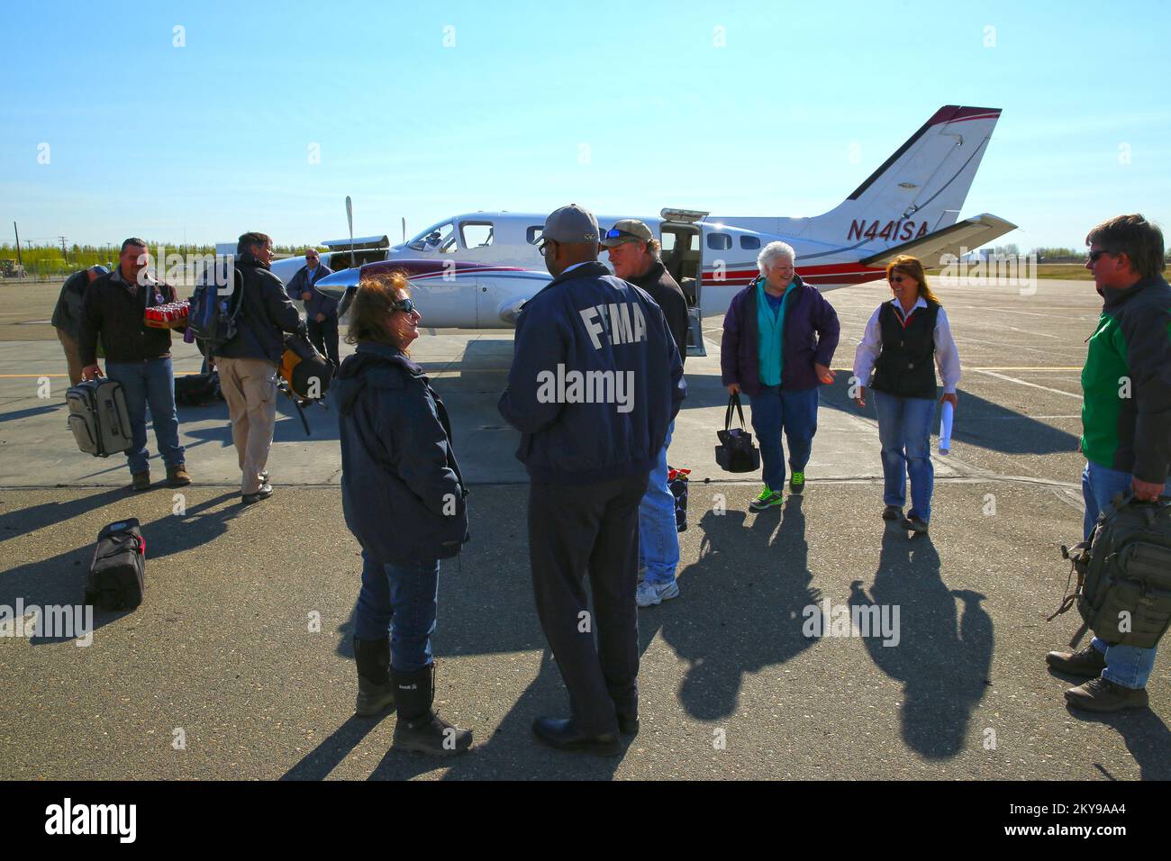 Galena, AK, 21 maggio 2014 l'ufficiale federale di coordinamento FEMA (FCO) Willie Nunn (c) viene informato da FCO Dolph Diemont (L) sulle operazioni di ripristino in caso di disastri sulla pista di volo locale. Dopo una grave inondazione che ha infuocato la comunità nel 2013, la FEMA e lo Stato dell'Alaska hanno lavorato a stretto contatto con la città di Galena per riversare l'infestazione critica alla comunità. Adam DuBrowa/FEMA. Inondazione dell'Alaska. Fotografie relative a disastri e programmi, attività e funzionari di gestione delle emergenze Foto Stock