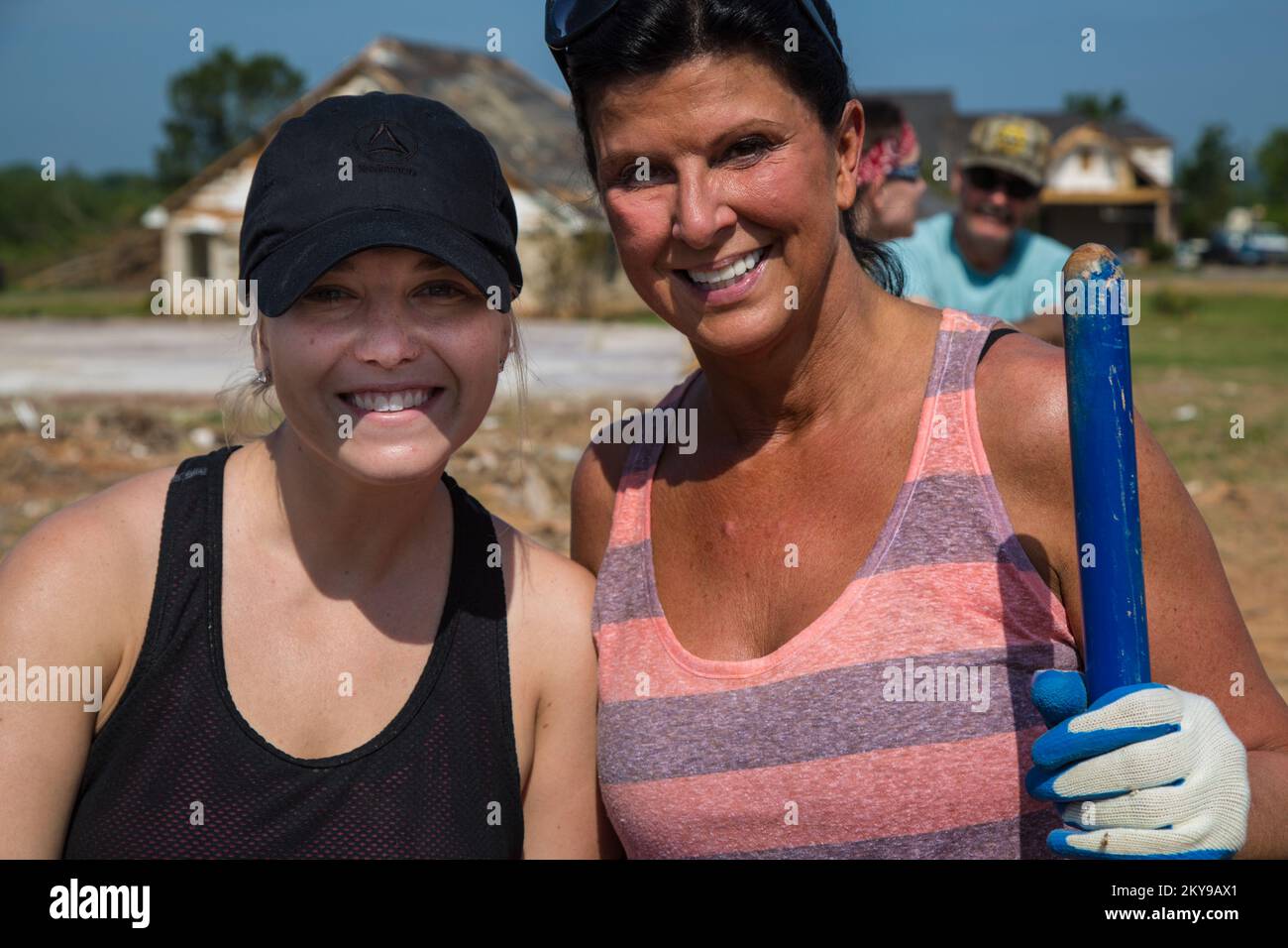 'Mayflower, AR, 22 maggio 2014; Mallory Fiddler (a sinistra) e Sherri Roussel (a destra), volontari di Reliance Health Care, sorridere per la fotocamera come aiutano il Team Rubicon a rimuovere i detriti da una casa e proprietà su Plantation Drive dopo che la casa è stata distrutta da un tornado il 27 aprile. La FEMA sostiene le organizzazioni volontarie attive in caso di disastri (VOAD) che aiutano i sopravvissuti a riprendersi dalle catastrofi naturali. Arkansas gravi tempeste, tornado e inondazioni. Fotografie relative a disastri e programmi, attività e funzionari di gestione delle emergenze Foto Stock