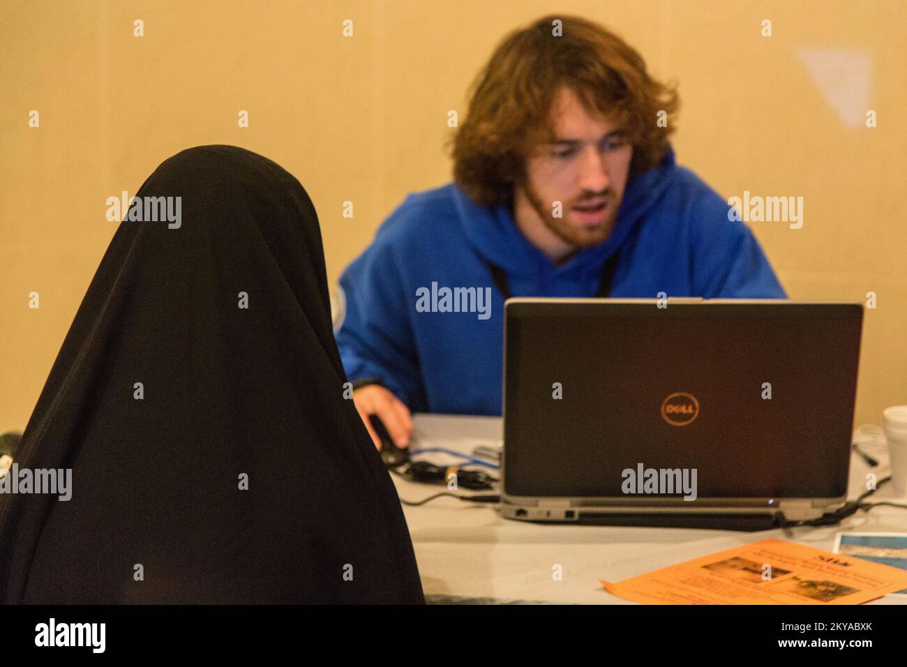 Dearborn, MI, 17 ottobre 2014 - David Andrew Chpernati (destra, giacca blu), FEMA Corps Silver 4 DSA Specialist, controlla il suo computer come egli aiuta un sopravvissuto al disastro registrarsi con FEMA in un Disaster Recovery Site (RSS) presso il Centro Islamico d'America a Dearborn, Michigan in risposta alle gravi tempeste e alluvioni del 11-13 agosto 2014 che hanno colpito negativamente le contee del Michigan di Wayne, Oakland e Macomb. La FEMA sostiene i governi locali e statali e le entità tribali nei loro sforzi per riprendersi dalle catastrofi naturali. Michigan forti tempeste e inondazioni. Fotografie relative al disgusto Foto Stock