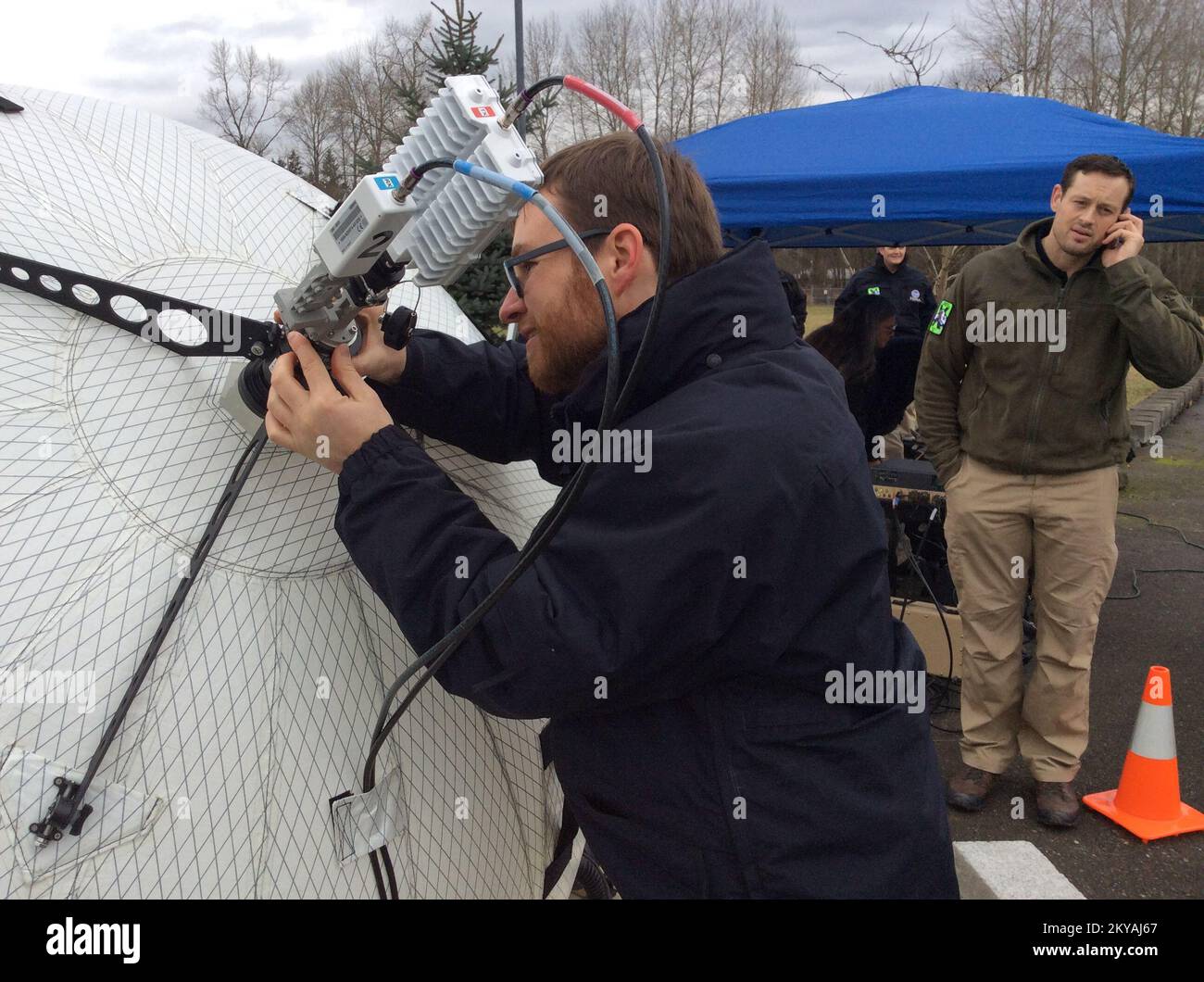 Stewart Matthesien regola l'antenna satellitare gonfiabile durante la valutazione operativa della preparazione operativa del team di assistenza alla gestione degli incidenti della Regione X di FEMA nel gennaio 2015 a Bothelpl, WA.. Stewart Matthesien regola l'antenna satellitare gonfiabile durante la valutazione operativa della preparazione operativa del team di assistenza alla gestione degli incidenti della Regione FEMA nel gennaio 2015 a Bothell, WA.. Fotografie relative a disastri e programmi, attività e funzionari di gestione delle emergenze Foto Stock