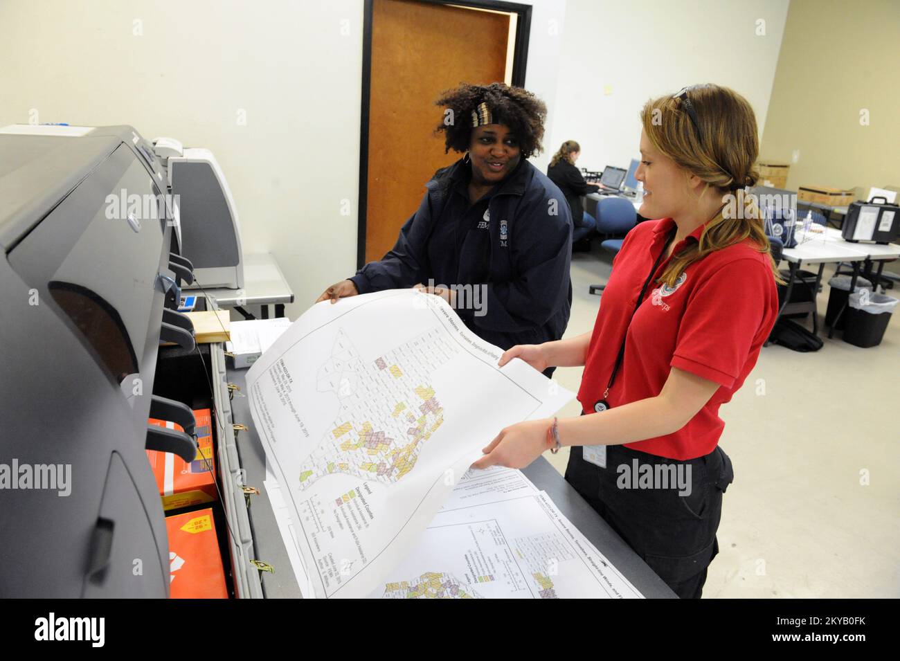 Austin, TX, USA 23 giugno 2015 il membro del FEMA Corps Melissa Jenssen, Right and Geospatial Information Systems Specialist Sharon Williams, stampa mas e materiali per i sistemi informativi geospaziali presso il Joint Field Office della FEMA ha organizzato le operazioni di disaster recovery nello Stato. I residenti colpiti dalle recenti inondazioni sono incoraggiati a registrarsi per il leasing di assistenza in caso di calamità chiama il numero 1-800-621-3362 (FEMA) o TTY: 1-800-462-7585 o online a www.disastperassistance.gov o m.fema.gov con un hone intelligente. Jocelyn. Austin, TX, USA--Giugno 23, 2015--membro del FEMA Corps Melissa Jenssen, Foto Stock