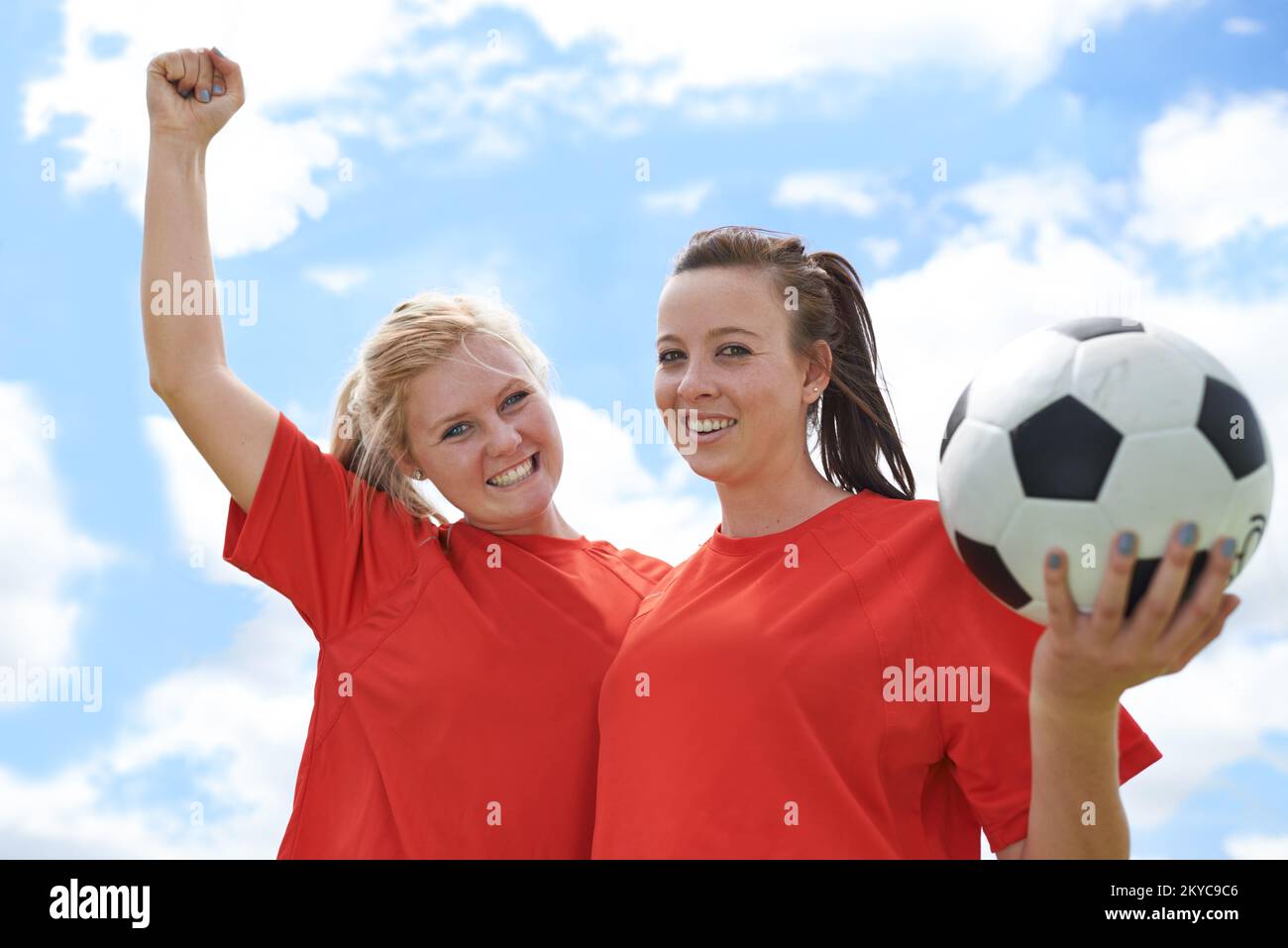 Celebrare un'altra vittoria. Ritratto di due giovani calciatrici in piedi su un campo di calcio. Foto Stock