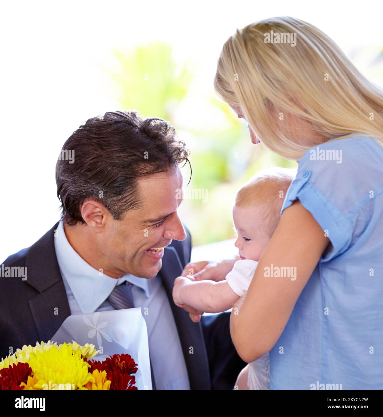 Non è il papà più dolce. Giovane uomo d'affari che porta i fiori a casa sua bella famiglia. Foto Stock