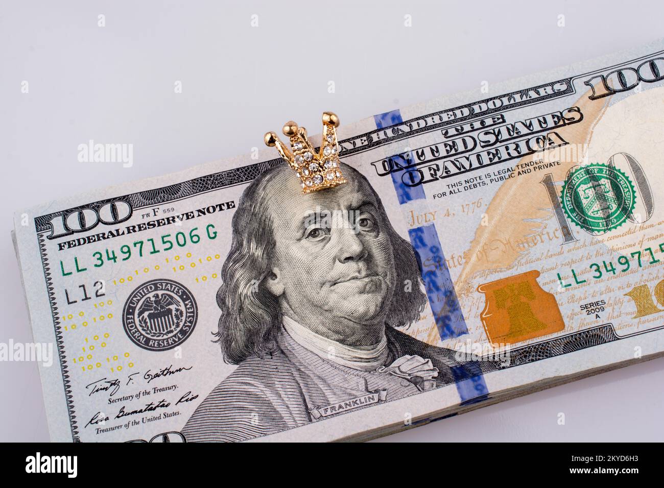 Banconote americane da 100 dollari e una corona color oro Foto Stock