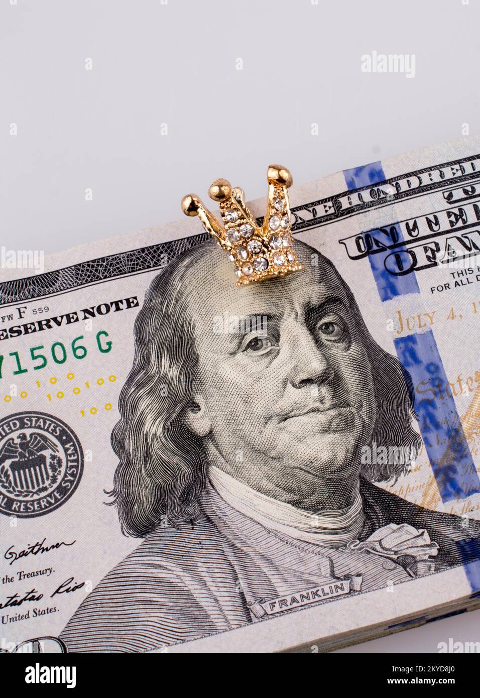 Banconote americane da 100 dollari e una corona color oro Foto Stock
