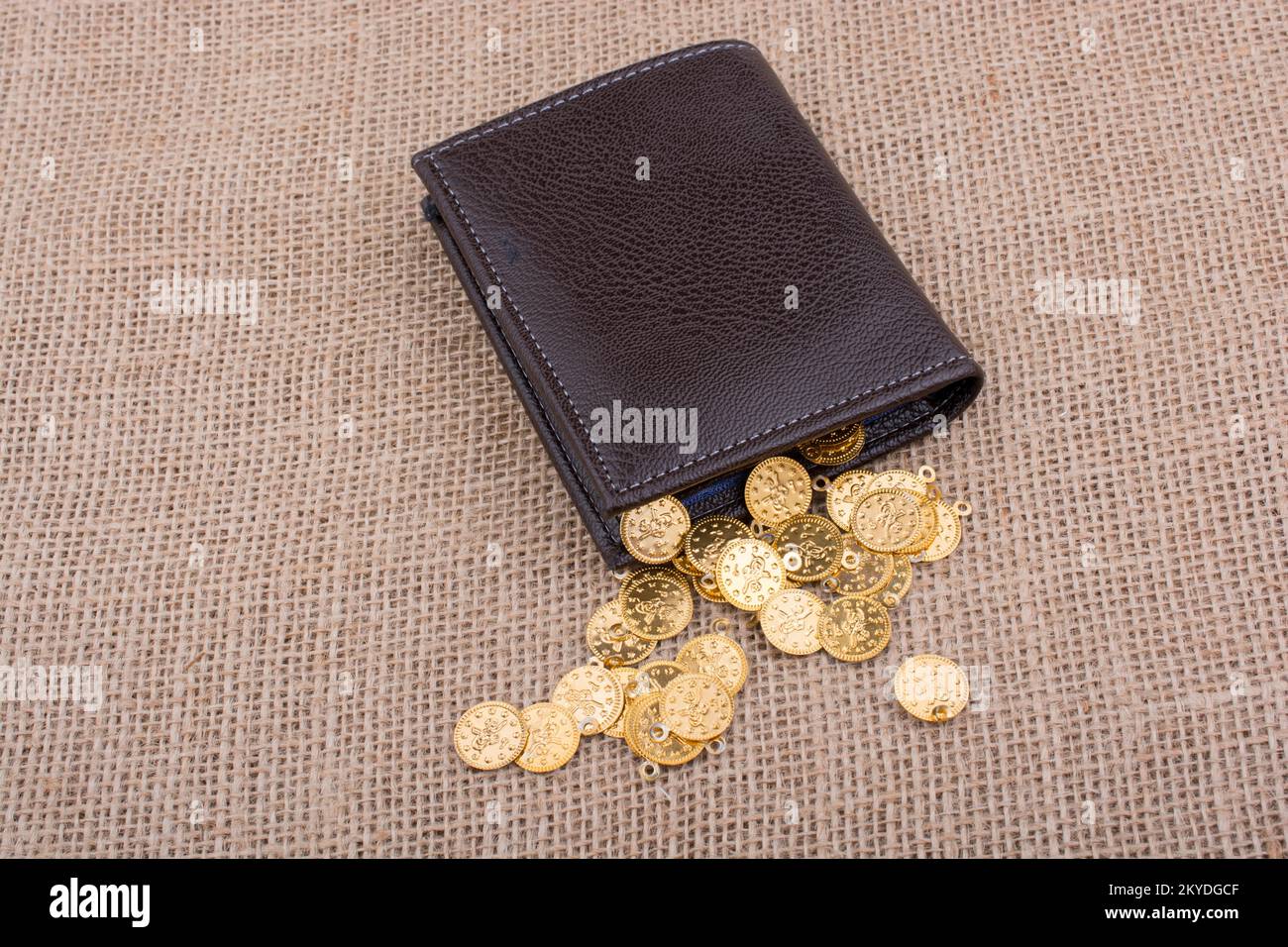 Portafoglio e abbondanza di false monete d oro su tela Foto Stock