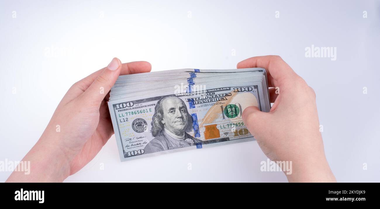 Mano umana tenendo dollaro americano Bill come denaro isolato su bianco Foto Stock