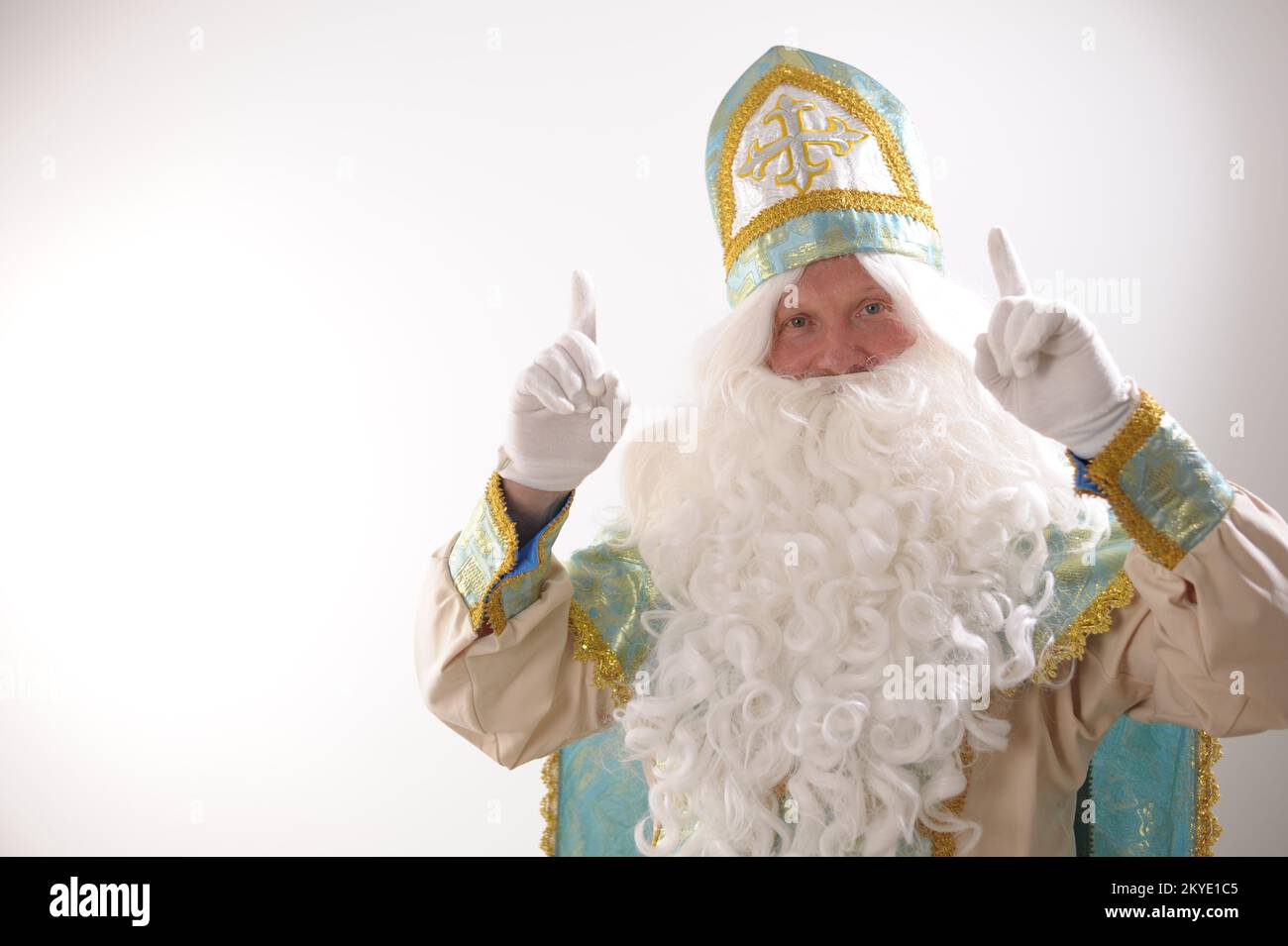 Ritratto di Sinterklaas USA su sfondo bianco. Olandese Babbo Natale St Nicholas natale nuovo anno barba bianca e abito blu dorato di San Nicholast sollevato due dita su Ascolta me guardare qui attenzione Foto Stock