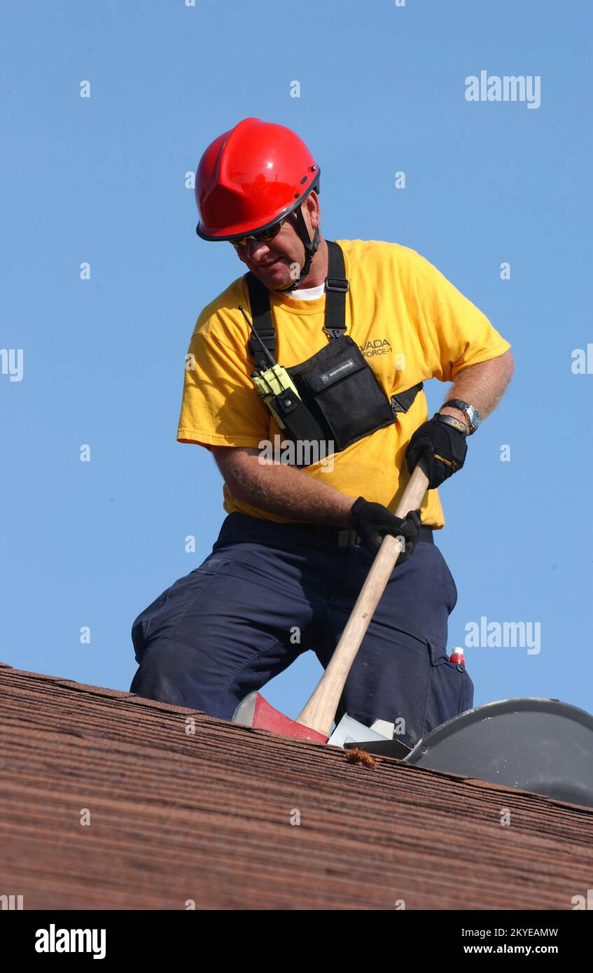 Uragano Katrina, New Orleans, LA, 6 settembre 2005 - le task force FEMA Urban Search and Rescue continuano le operazioni di ricerca nei quartieri colpiti dall'uragano Katrina. Un lavoratore di salvataggio batte sul tetto alla ricerca di residenti che possono essere intrappolati nella casa. Jocelyn Augustino/FEMA Foto Stock