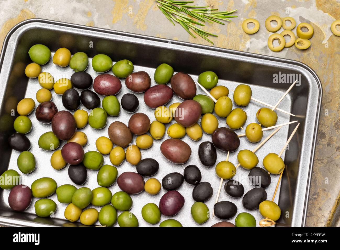 Diverse varietà di olive in un vassoio di metallo Fondo in metallo arrugginito. Giacitura piatta. Foto Stock