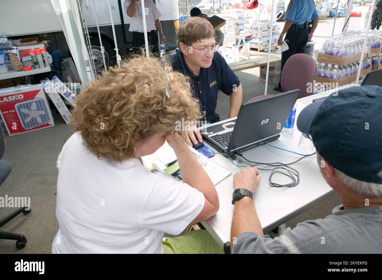 Uragano Katrina, Waveland, MS., 9/19/2005 -- Un impiegato di assistenza di disastro di FEMA aiuta le vittime di uragano Katrina con una domanda ad un centro disaster recovery di FEMA. I centri sono istituiti per aiutare le persone colpite dall'uragano a ricevere assistenza per alloggi temporanei e prestiti SBA. Andrea Booher/FEMA Foto Stock