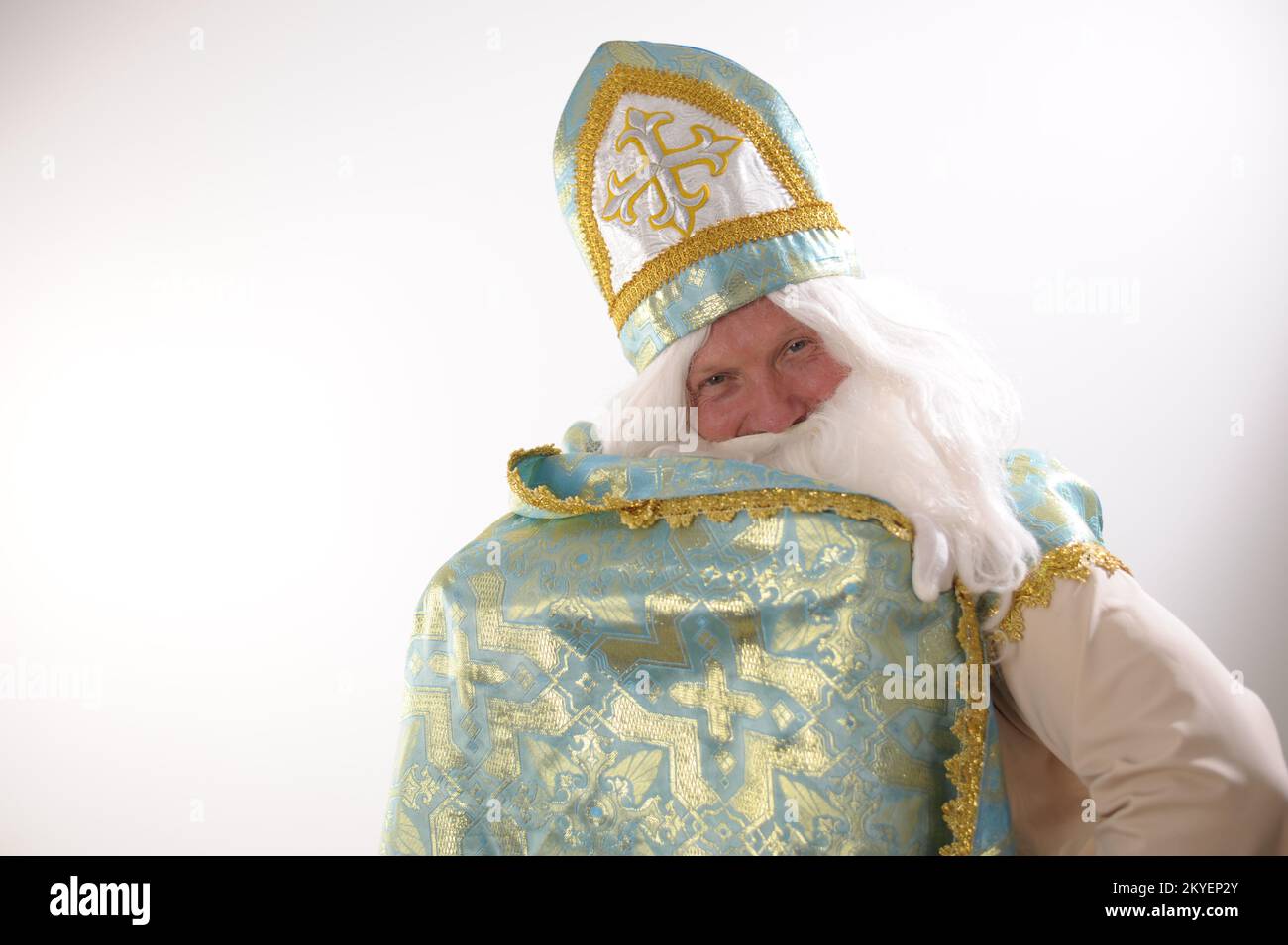 Spazio pubblicitario per il ritratto di testo Sinterklaas. USA su sfondo bianco. Olandese Babbo Natale St Nicholas natale nuovo anno lungo mantello San Nicholas sollevato con una mano e avvolto Foto Stock