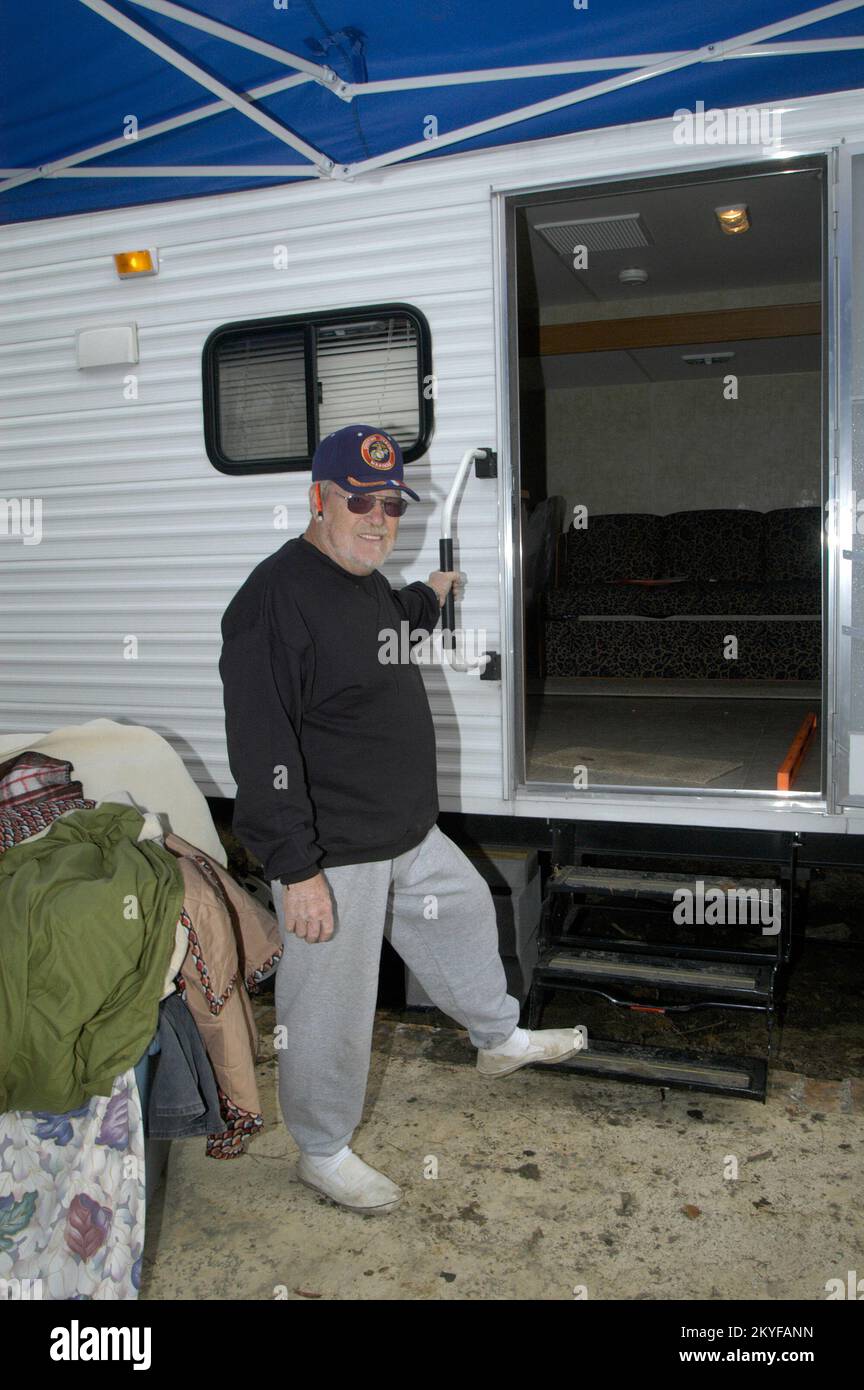 Uragano Katrina, Waveland, MS, 10 dicembre 2005 -- Dan McManus si trova davanti al suo nuovo trailer FEMA. A lui e a sua moglie Susan è stato consegnato il trailer di viaggio conforme agli standard ADA dopo che è stato scoperto che Susan McManus era stato disabilitato e non era in grado di utilizzare il primo trailer FEMA che gli è stato consegnato. Patsy Lynch/FEMA Foto Stock