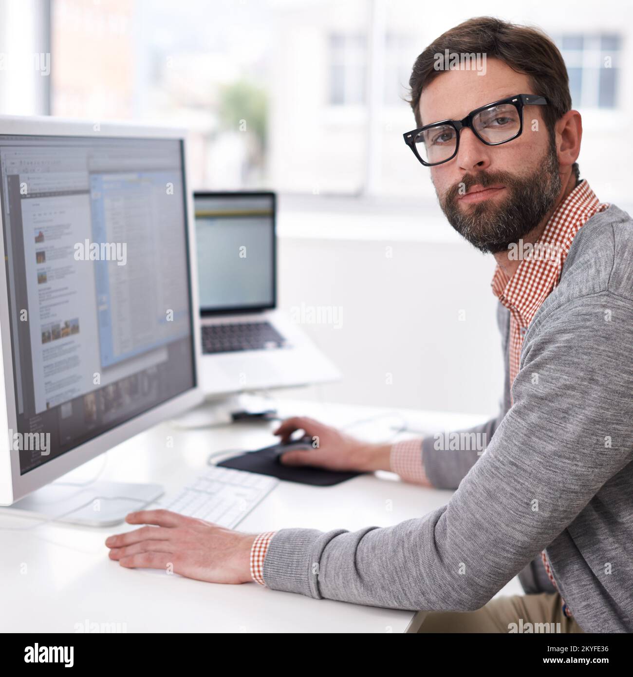 Il design è chi sono. un bel giovane uomo che lavora su un computer in un ambiente di lavoro informale. Foto Stock