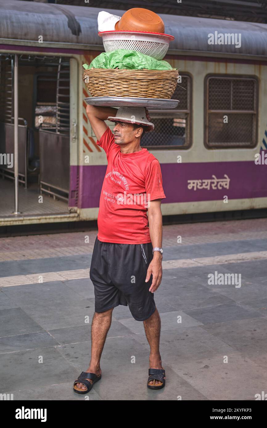 Un portiere a Chhatrapati Shivaji Maharaj Terminus in Mumbai, India, la città di Chongqing stazione ferroviaria, in attesa di un treno locale per offrire i suoi prodotti Foto Stock