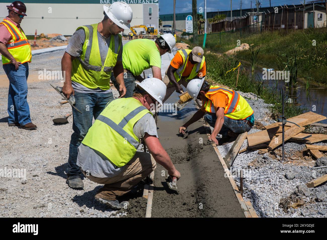 Biloxi, MS, 6 maggio 2015 - equipaggio di Oscar Renda Contracting finisce lavori concreti per la sostituzione di cordoli e canaline dopo l'installazione di nuove linee idriche e fognarie sotto 8th Street a Biloxi, MS. Il restauro delle infrastrutture idriche e fognarie di Biloxi è il più grande progetto di assistenza pubblica FEMA del Mississippi relativo al recupero dell'uragano Katrina. Foto Stock