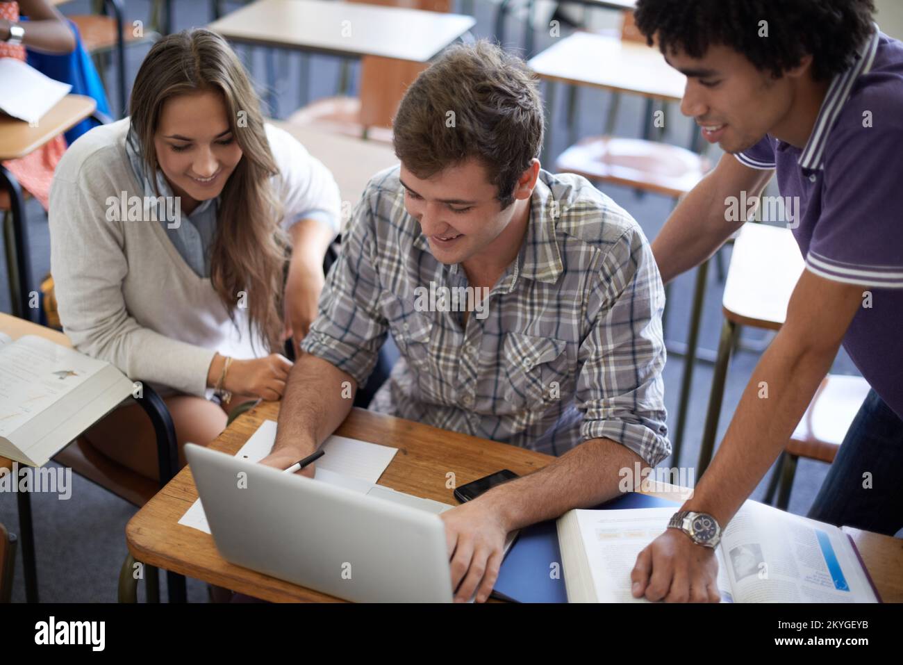 Un po' di controllo dei fatti online. un gruppo di studenti universitari che lavorano sui computer portatili in classe. Foto Stock